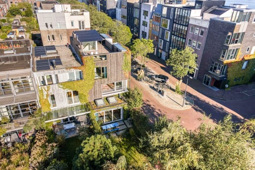 Aerial view of modern buildings displaying eco-friendly designs surrounded by lush greenery, showcasing a harmonious blend of architecture and nature.