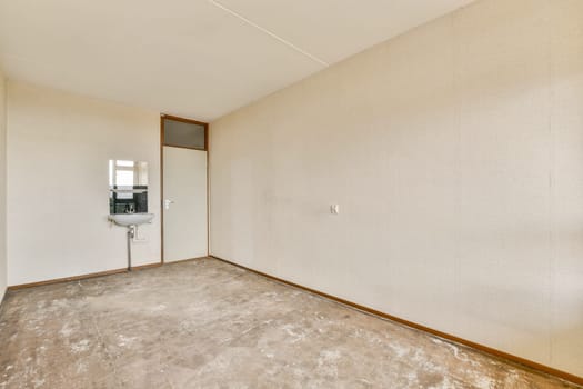 A vacant room featuring simple walls, a door, and a mirror, showcasing minimalist and modern interior design aesthetics.