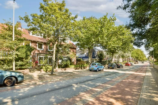 A picturesque view of a residential street lined with vibrant trees, showcasing parked cars and charming houses on a sunny day.