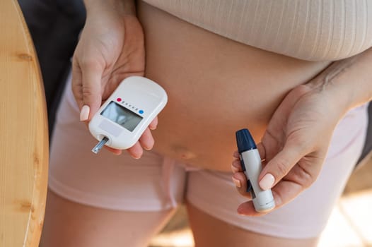 Pregnant woman doing home blood sugar test. Gestational diabetes