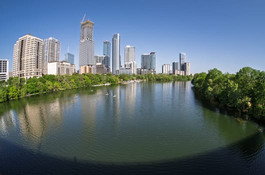 Fisheye lens view of Austin skyline from Congress bridge over the calm waters of Colorado river in Texas