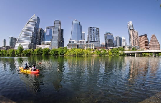 Austin, TX - 10 April 2025:Skyline of the downtown district with fisheye lens with kayakers on Colorado river in spring