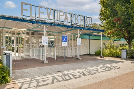 An inviting entrance gate showcases a park's name, surrounded by greenery and a well-maintained pathway, ready for visitors to explore.