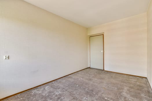 A spacious, empty room featuring neutral walls and a single door, showcasing a clean, minimalist design perfect for various interior styles.