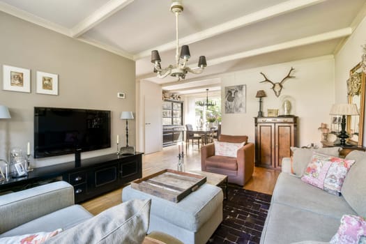 A beautifully designed modern living room showcasing a stylish sofa, tasteful decor, and warm lighting, perfect for relaxation and social gatherings.