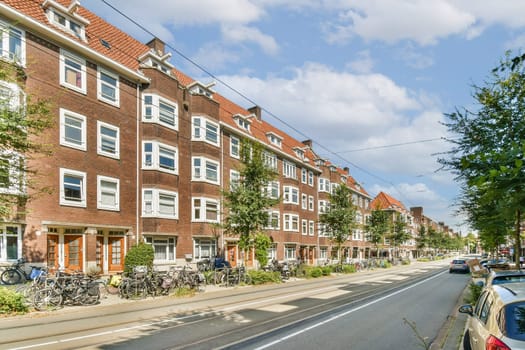 A picturesque urban street featuring charming historic buildings, lined with lush trees and parked bicycles, inviting a serene atmosphere for pedestrians.