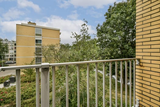 A beautiful perspective from a balcony showcasing lush greenery and modern architecture in a tranquil setting, ideal for relaxation and outdoor enjoyment.