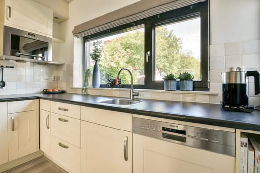 A sleek kitchen design featuring contemporary cabinetry, a view of greenery through the window, and stylish appliances for an inviting atmosphere.