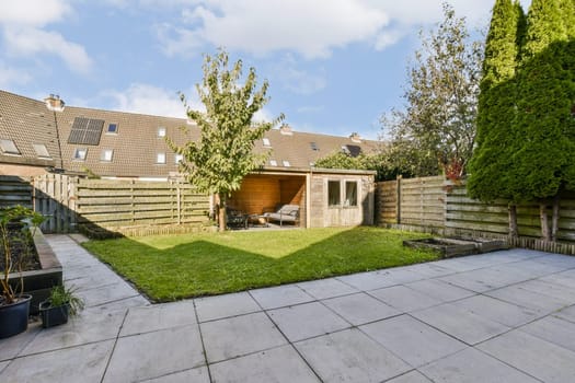 A beautifully maintained garden featuring lush green grass, a wooden shed, and well-trimmed hedges, ideal for relaxation and outdoor activities.