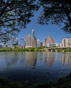 Fisheye lens view of Austin skyline including Congress bridge over the calm waters of Colorado river in Texas