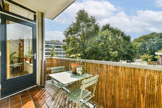 A bright and inviting balcony adorned with lush greenery and a cozy seating arrangement, perfect for relaxing outdoors in a serene environment.