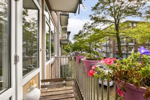 A vibrant urban balcony showcasing blooming flowers in colorful pots, surrounded by greenery and modern architecture, creating a lively outdoor space.