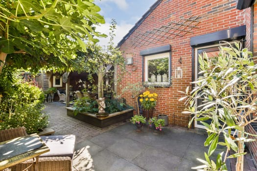 A beautiful garden entrance featuring stone pathways, vibrant flower pots, and lush greenery, creating a warm and inviting atmosphere.