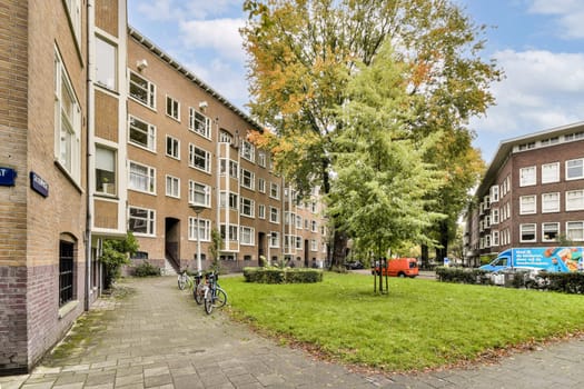 A view of an urban residential area featuring buildings, well-maintained lawns, and parked bicycles. A glimpse of city life blending with nature.