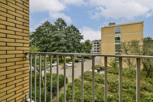 A picturesque view from a balcony showcasing greenery, residential buildings, and a peaceful environment, ideal for relaxation and enjoying nature.