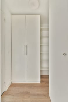 A bright and airy room featuring a sleek white wardrobe and light wooden flooring, showcasing minimalist interior design principles for a modern aesthetic.