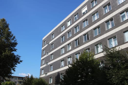 A sprawling and expansive building adorned with numerous windows, basking in the warm sunlight of a bright and beautiful day