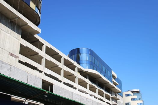 A modern building featuring a striking blue facade is presently under construction and will soon contribute to the urban skyline