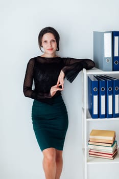 Woman in business suit working at the shelf with documents secretary
