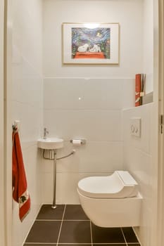 This contemporary bathroom features sleek lines and a clean aesthetic, showcasing white tiles, minimal fixtures, and artistic wall decor for a stylish touch.