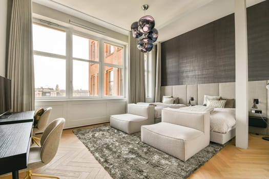 A chic and modern hotel room featuring large windows that allow natural light to fill the space, harmonizing style and comfort with elegant furnishings.
