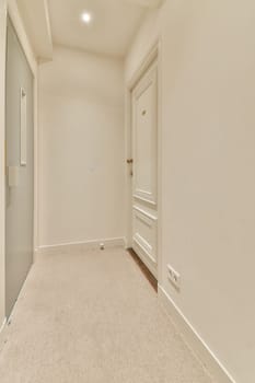 A spacious hallway featuring soft carpet and clean lines, illuminated by natural light, emphasizing a modern and minimalist aesthetic.