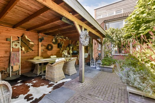 A beautifully arranged outdoor patio featuring wooden beams, natural decor, and a inviting dining area surrounded by lush greenery.