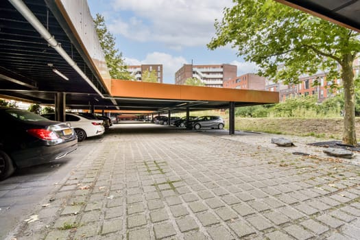 A spacious modern parking area designed with a combination of artful architecture and natural elements like trees, creating a visually appealing environment.