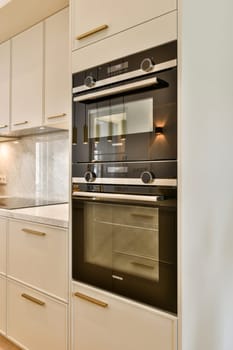 A sleek and contemporary kitchen featuring elegant cabinetry, sophisticated ovens, and high-end finishes, creating a chic culinary space.