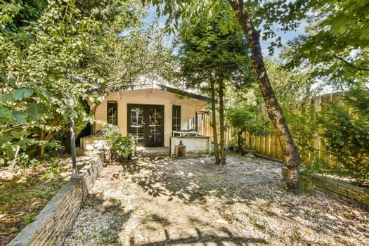 A picturesque garden cottage nestled among verdant trees and plants, featuring a cozy entrance and serene outdoor space, perfect for relaxation and nature lovers.