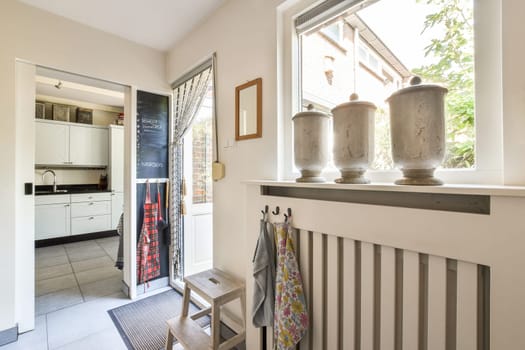A fresh, inviting kitchen entryway with sleek design elements, showcasing contemporary fixtures, stylish decor, and natural light streaming in from windows.