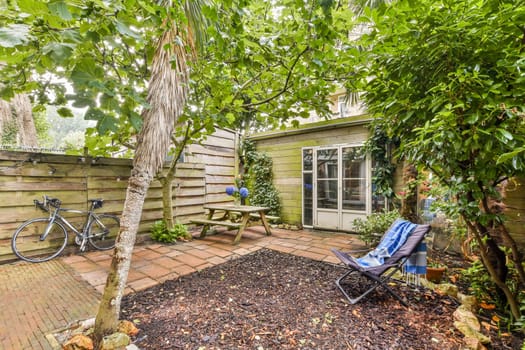 A serene garden featuring lush greenery, a cozy seating area, and a bicycle, perfect for relaxation and enjoying nature.