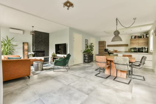 An elegant open-plan space featuring a cozy living area with a stylish couch, dining table, and a well-equipped kitchen, showcasing contemporary design and comfort.
