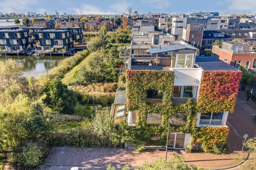 The image showcases innovative, eco-friendly buildings adorned with greenery nestled in an urban environment, capturing a blend of nature and modern design.