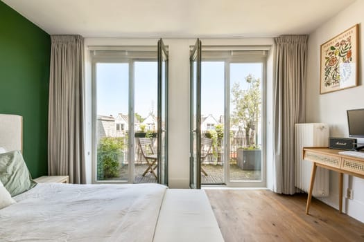 A contemporary bedroom featuring large windows that offer a view of the outdoor garden, paired with elegant furnishings and a calming color palette.