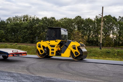 Heavy asphalt road roller that press new hot asphalt on the roadway on a road construction site on a street