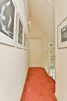 A contemporary hallway features framed art, a beige wall, and a red carpeted floor, creating a warm and inviting atmosphere for home decor.