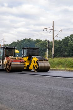 Two Heavy Asphalt Road Roller that press new hot asphalt on the roadway on a road construction site on a street
