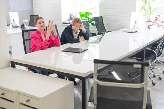 Caucasian Businesswoman Uses Smartphone While Colleague Has Problems At Work