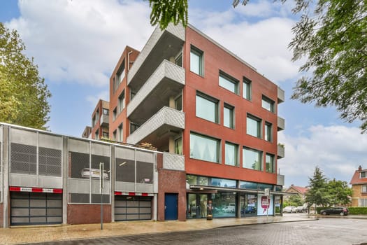 This image showcases a contemporary building featuring large windows and a sleek design, surrounded by lush trees and clear skies, highlighting urban life.