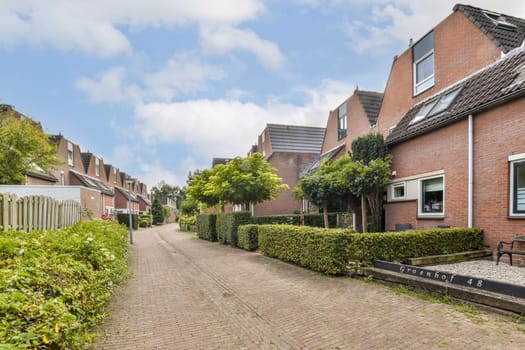 Peaceful view of a suburban street lined with houses and lush greenery, offering a blend of nature and modern living. Ideal for those seeking tranquility in an urban setting.