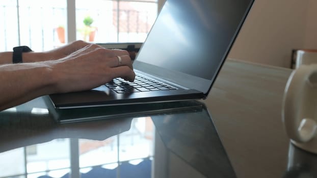 A professional workspace featuring a laptop on a table. Hands typing on the keyboard, showcasing technology and productivity in a clean, inspiring environment.
