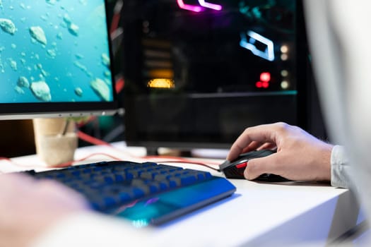 Person in neon lit apartment playing singleplayer videogame with spaceship shooting laser bullets at asteroids. Close up of gamer using crosshair overlay to hit targets in science fiction arcade game