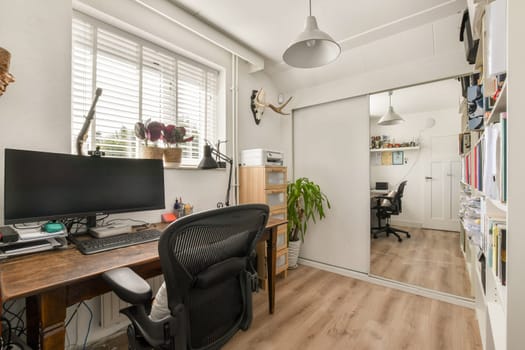 A sleek and organized home office featuring a desk with a computer, a comfortable chair, and decorative plants, providing an inviting workspace atmosphere.