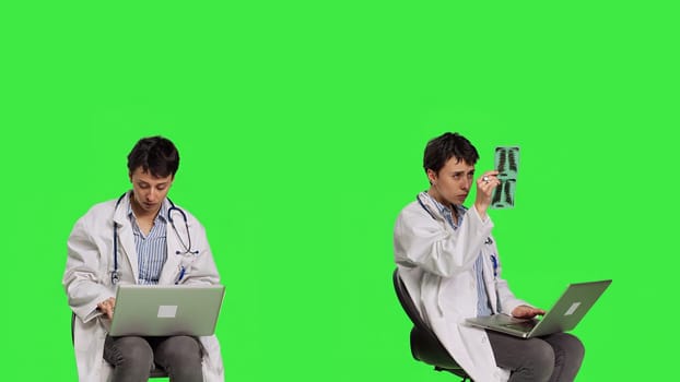 Physician doing research with a x ray scan result against greenscreen backdrop, examining radiography diagnosis to help patients with disease. Woman doctor studying radiology in studio. Camera B.