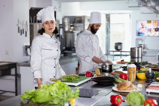 Culinary professional creating gourmet meals with kitchen tools and fresh produce, working in a restaurant kitchen with coworkers. Cooking on the stove, and carefully following recipes.