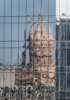 Reflection of the Texas State Capitol dome in the multiple glass windows of modern skyscraper in Austin