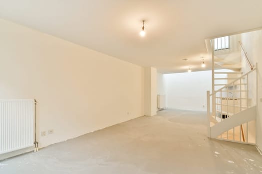 A spacious, unfinished modern interior featuring clean lines, neutral colors, and ample natural light. It includes a spiral staircase and minimalistic design elements.