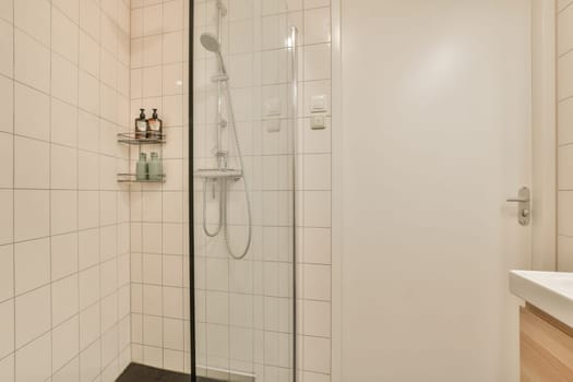 A sleek and contemporary shower room featuring a glass enclosure, minimalist design, and light-colored tiles for a clean, spacious feel.
