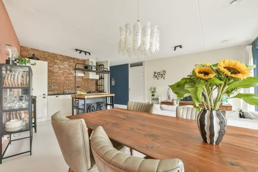 A stylish dining area featuring a wooden table, elegant chairs, and vibrant sunflowers in a vase, complemented by contemporary decor and a cozy atmosphere.